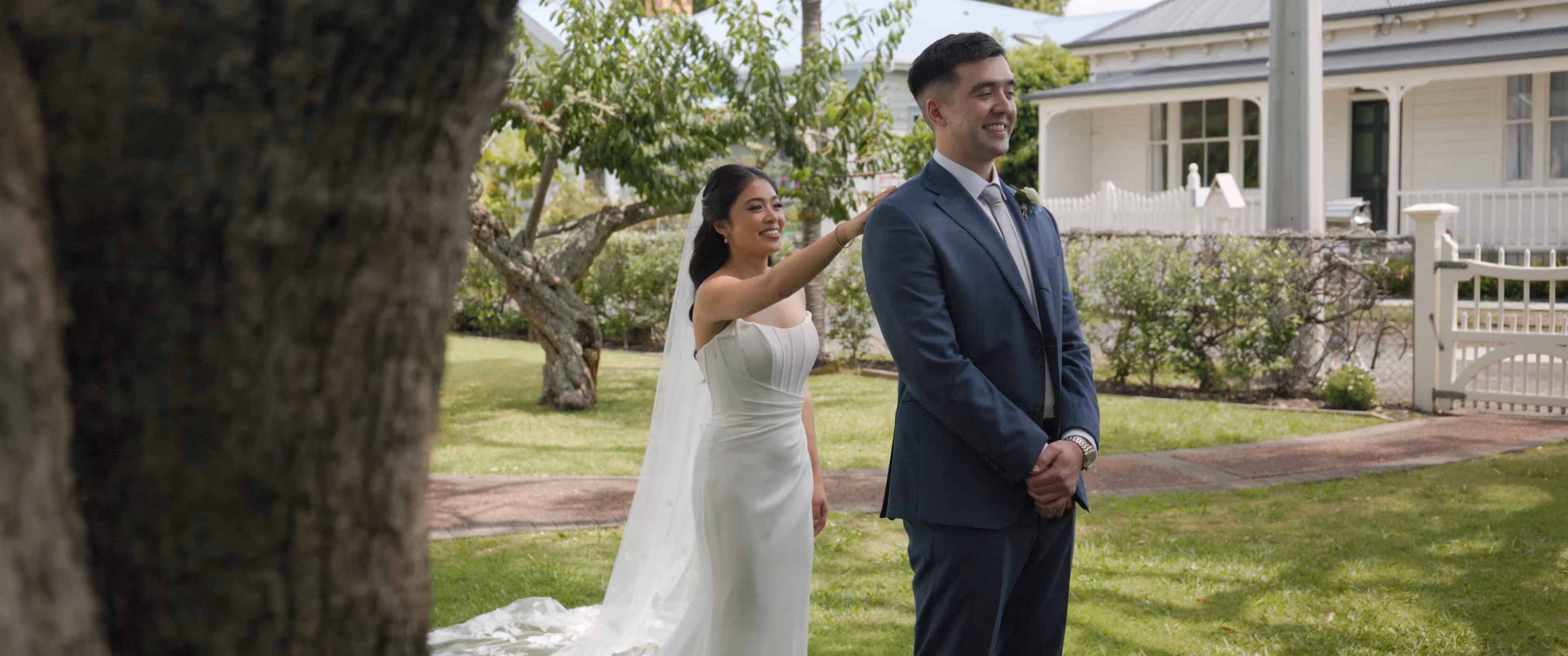 Jennifer and Terence sharing a quiet first look in a lush Auckland garden before their Mantells ceremony