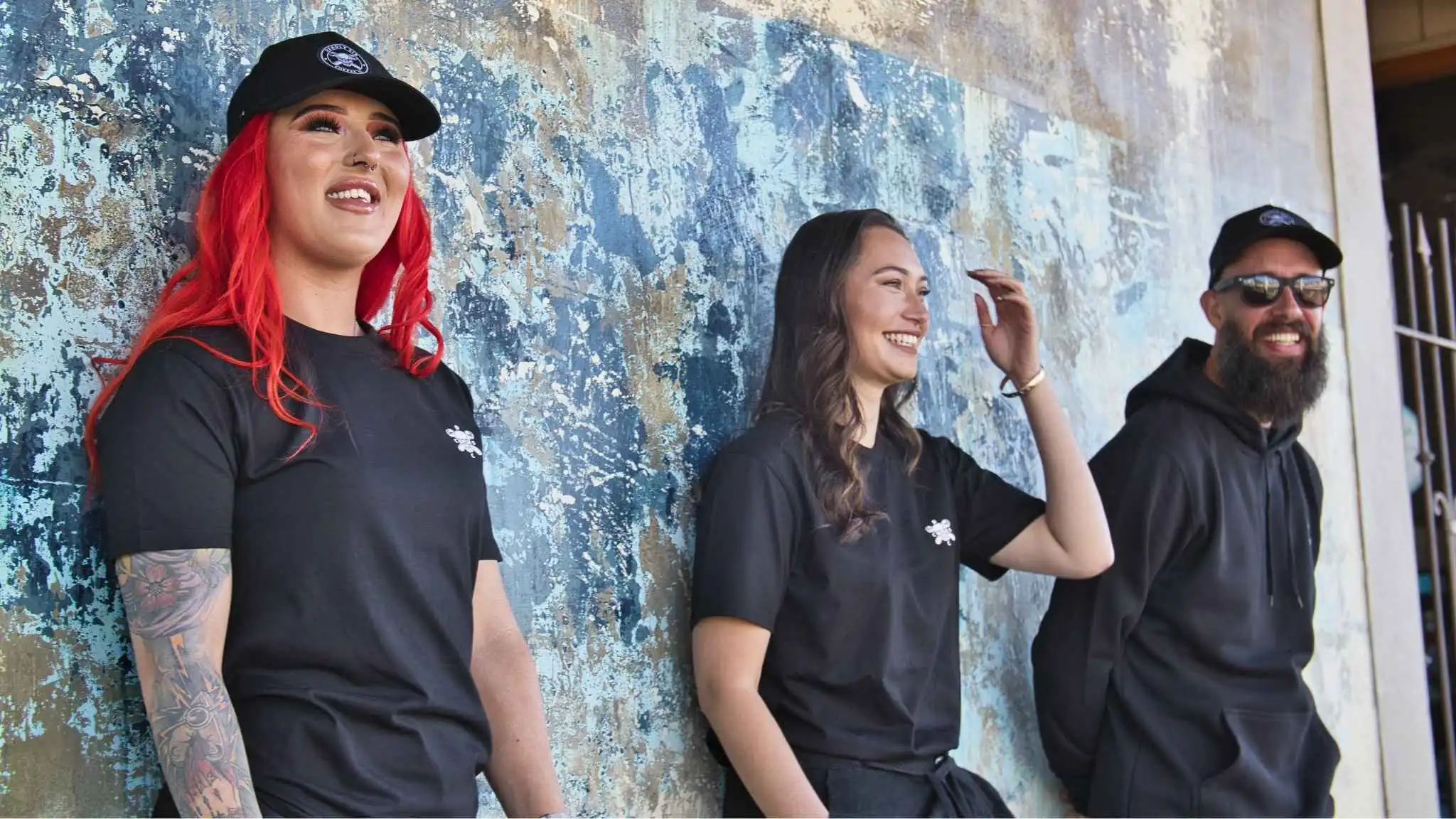 Deadly Sin Coffee Co. team photo with mural backdrop.