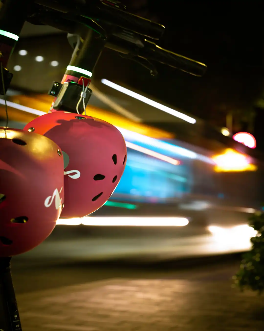 Pink scooter helmets with colourful light streaks.