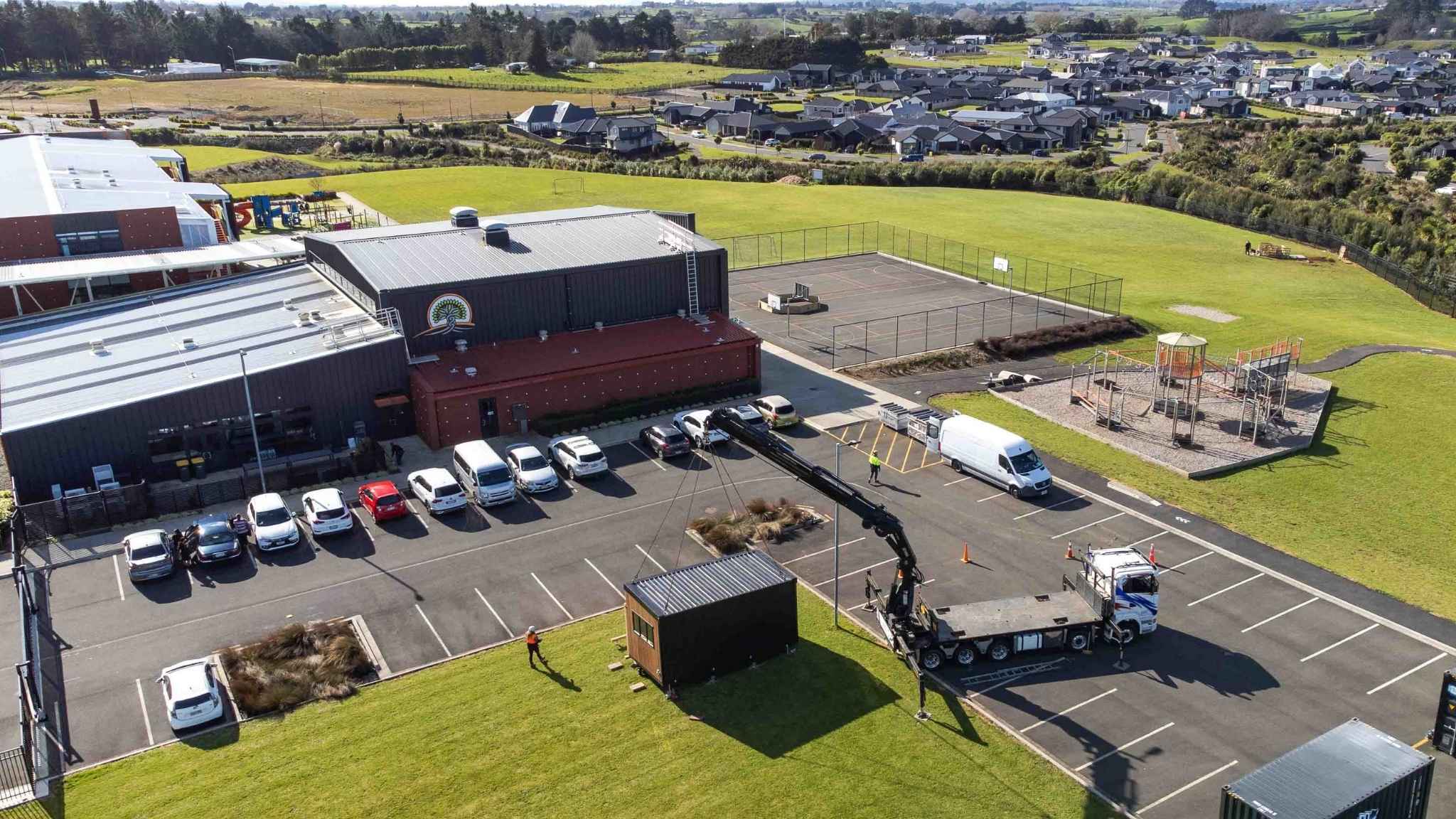 Aerial drone photo of commercial site with modular unit placement near carpark and surrounding Paerata school office.