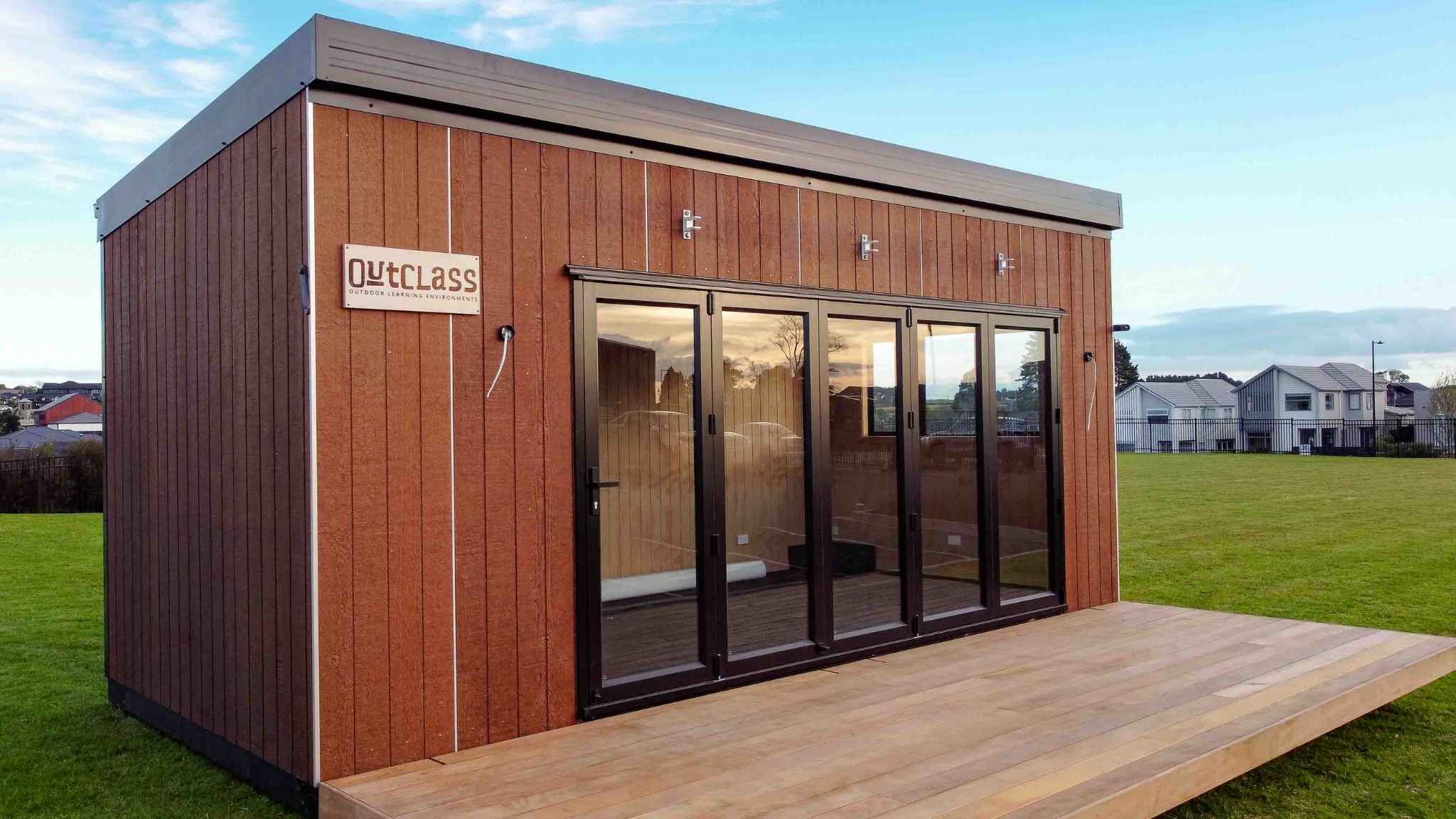 Newly installed modular showroom building with timber exterior cladding and glass front doors.