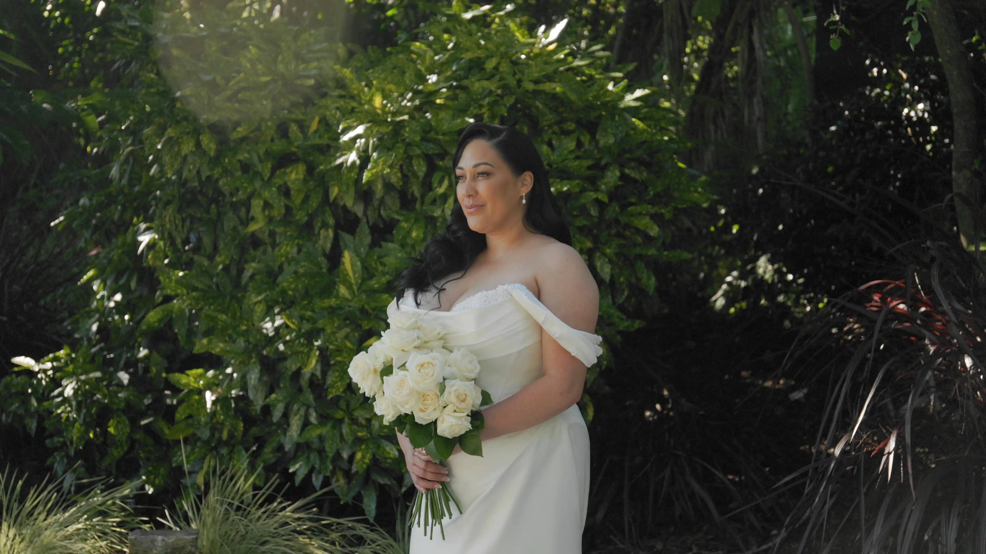 Bride portrait captured by Auckland wedding videographer during outdoor garden ceremony.
