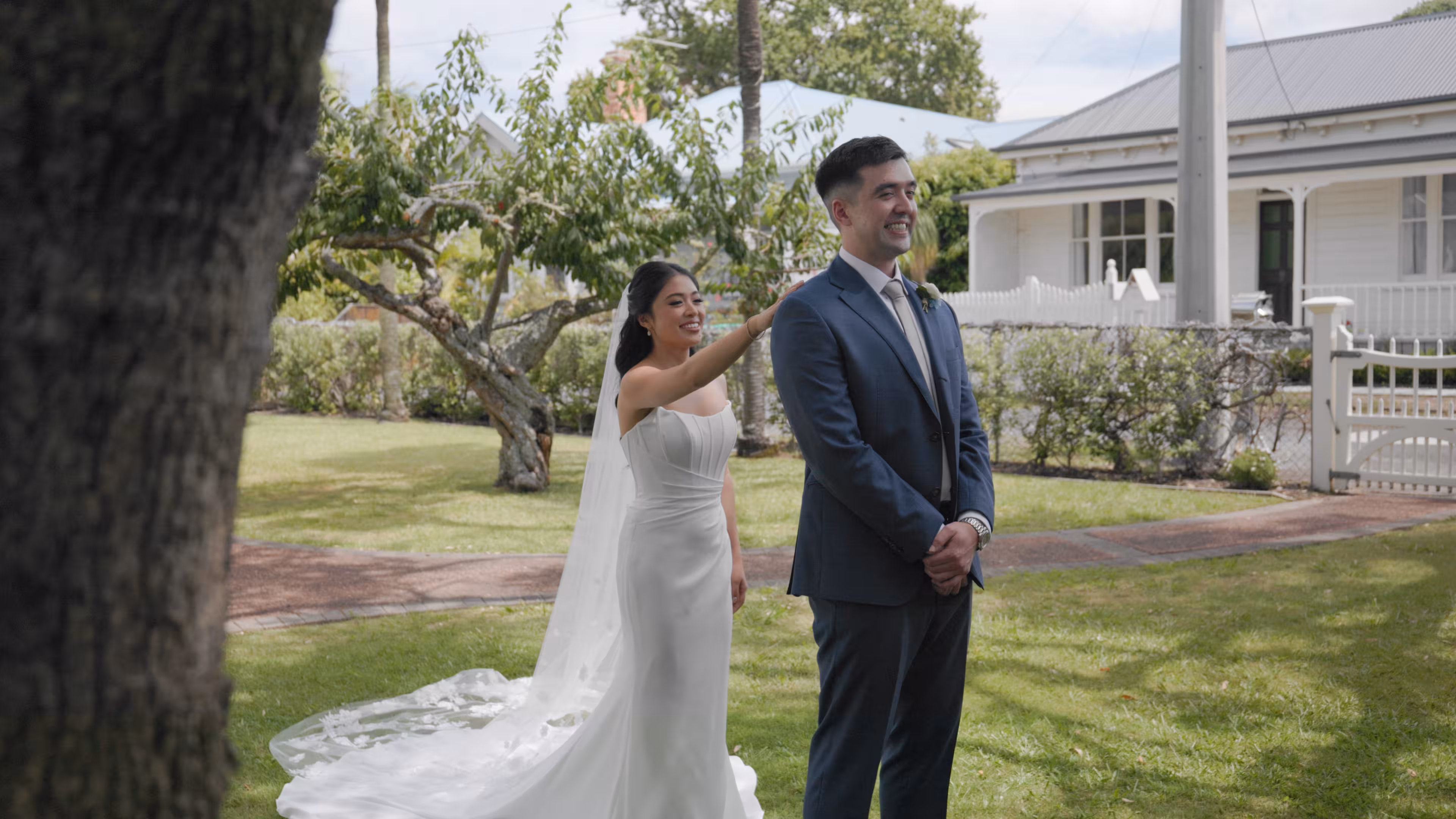 First look between bride and groom captured by Auckland wedding videographer during outdoor garden wedding preperation in Devonport.