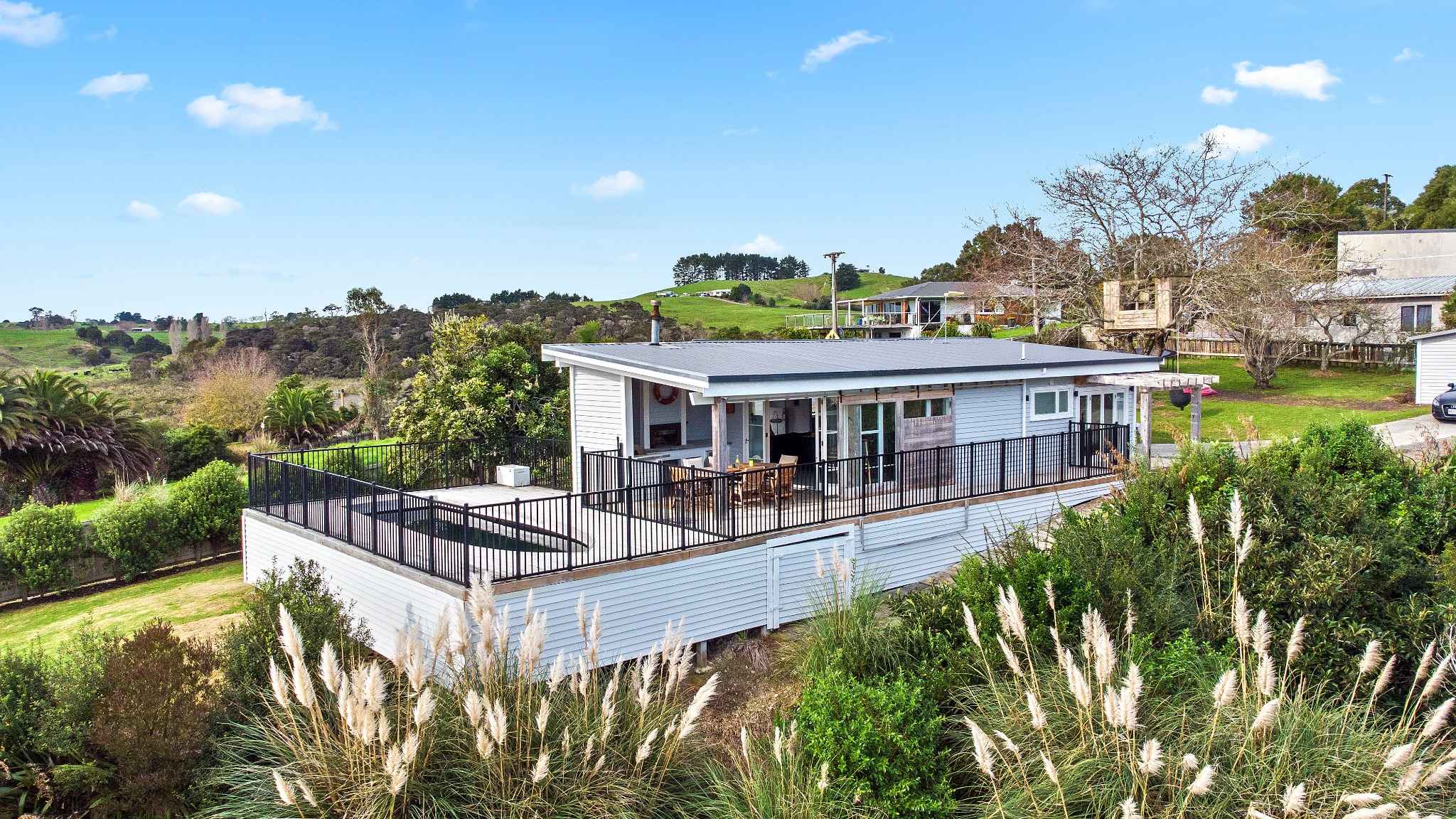 Modern Auckland property with large deck, landscaped garden, and elevated outdoor views.